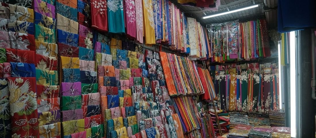 A busy saree and fabric shop aisle